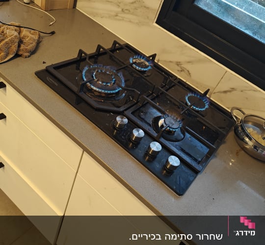 כיריים גז עם להבות כחולות במטבח מודרני